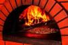 A pizza baking in a brick oven.