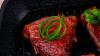 Grilled beef fillet strips on grill teflon black plate over wood 1920x1080 intro motion slow hidef hd - HD stock video clip