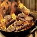Meat cooking over a big fire on the grill