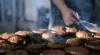 Hamburgers kooking on a barbeque grill with flames and smoke