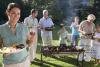 Three generation family standing beside barbecue grill in garden